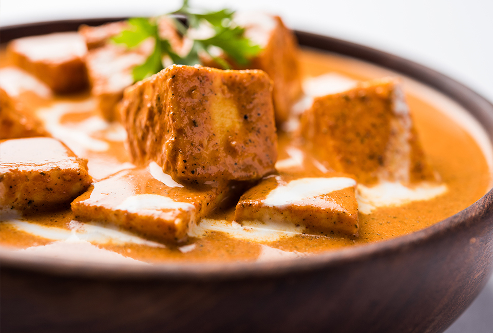 Orange, creamy soup topped with croutons and herbs.