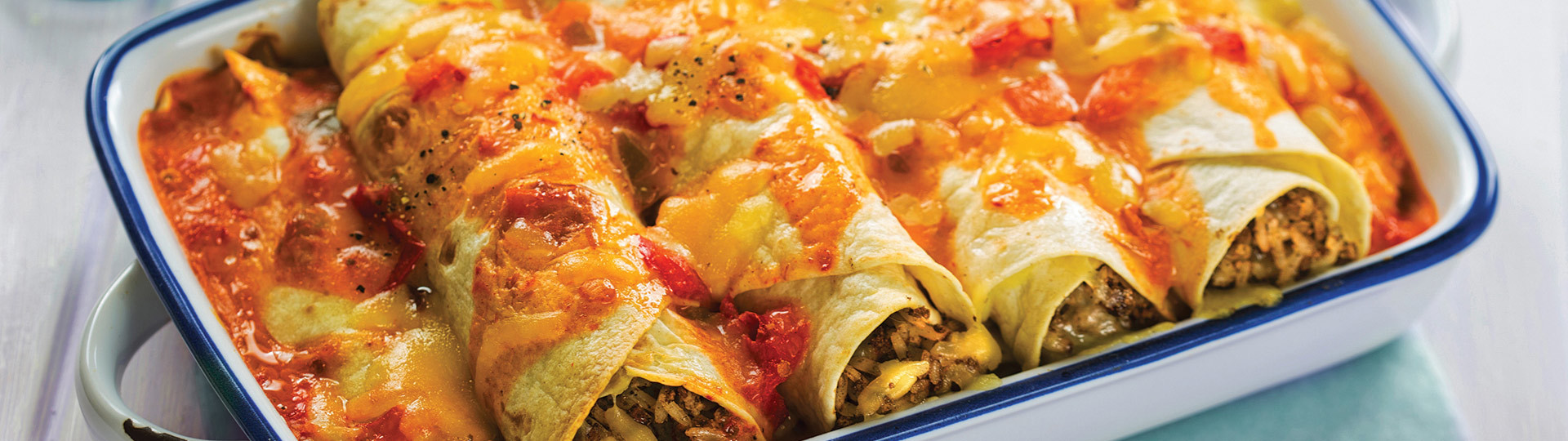 Enchilada dish with cheese and salsa topping.