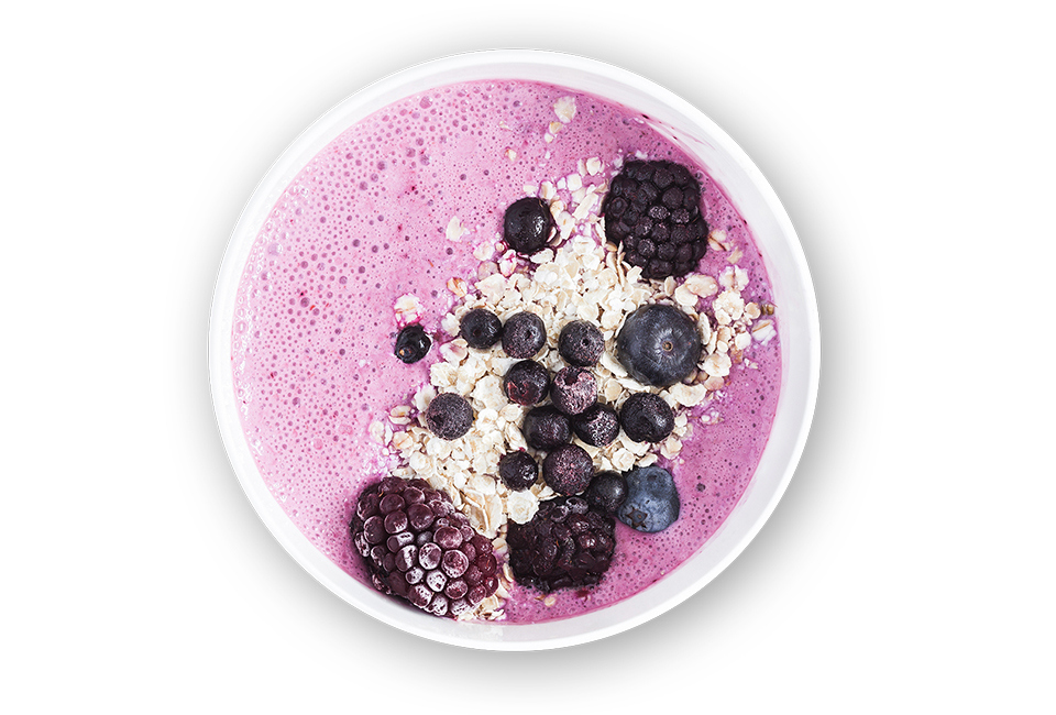 Purple smoothie bowl topped with oats, blueberries and blackberries.