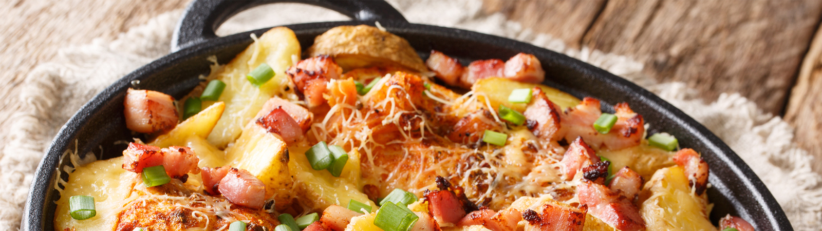 skillet with potatoes and cheese topping